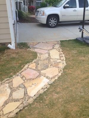 Install Tn natural stone steppers to the top of the french drain set in Cedar Creek decorative gravel.