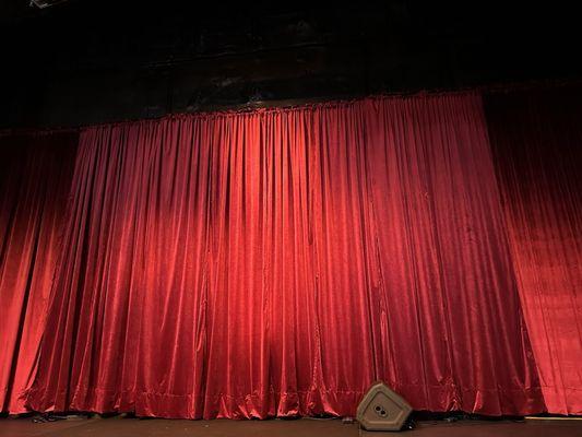 Red theatre curtains provide swanky backdrop for the stage