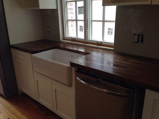 Shaker kitchen in white with a custom walnut countertop.