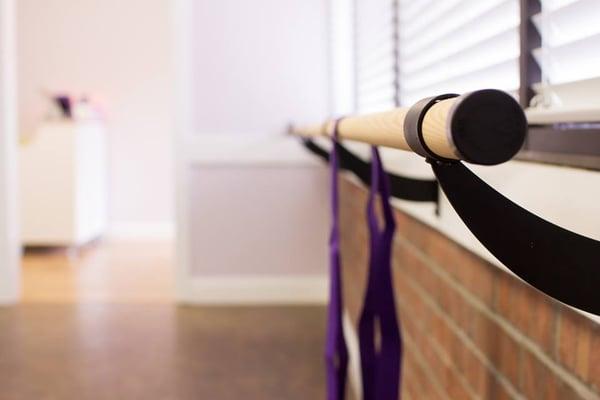 The use of a ballet barre allows clients to engage muscles otherwise difficult to isolate.