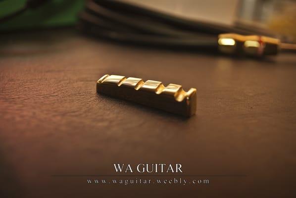 A handmade brass nut, ready for installation on a 5-string bass.