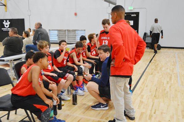 Coach Flitter and Coach Hudson discuss strategy during a timeout.