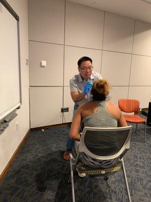 Dr. Nguyen doing athlete dental exams at the University of Texas at Arlington