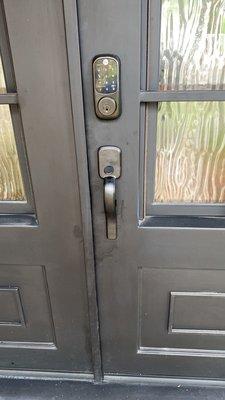 Electronic keypad and handle set installation on iron front door.