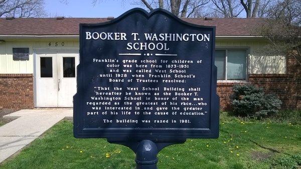 Historical site marker along the sidewalk