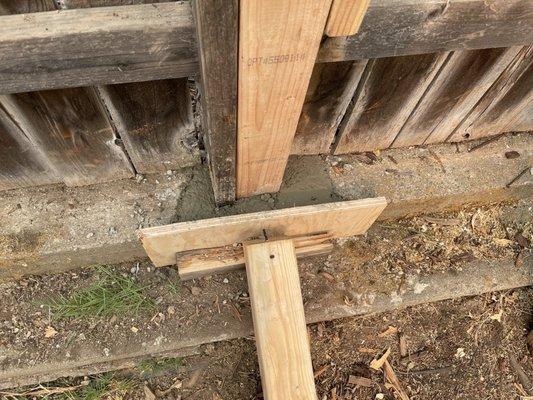 Close up of forms placed for the pouring and forming of cement to brace new fence post.