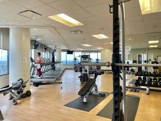 Large room with cardio equipment (facing the windows) as well as weight machines + free weights