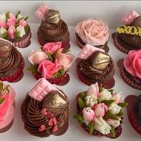 Romantic-themed cupcakes decorated with pink roses, chocolate hearts, and edible bars, perfect for a special celebration.