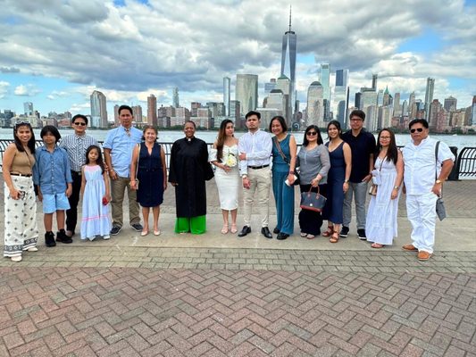 Entire wedding party at the waterfront with the Freedom Tower in the background.