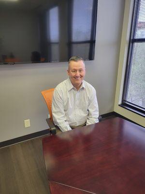 Val Daubert sitting in conference room.