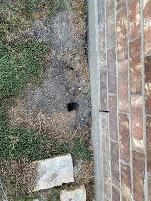 holes increasing all around the duplex showing the house was sliding off foundation.