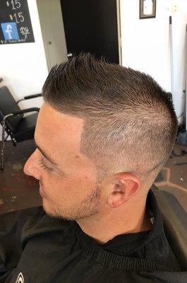 1 fade on the sides with tapered neck and with light trim on top. Also, a groomed and shaped beard.