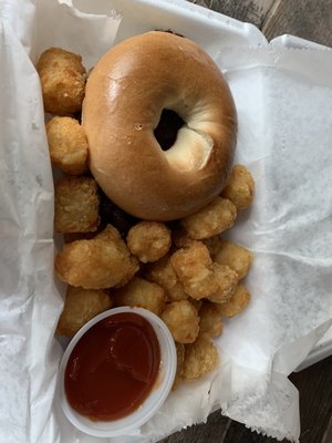 Well done bacon, egg and cheese bagel with tator tots.