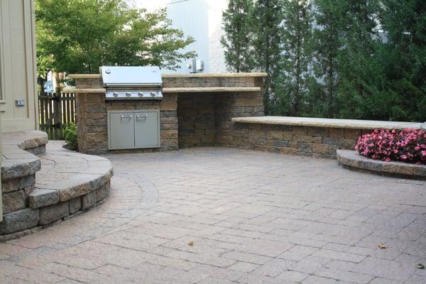 Custom designed paver patio with built-in grill, seating wall & flower planter.