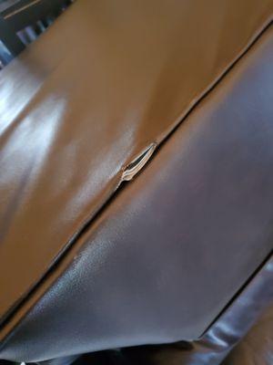 Torn leather on back of recliner that was done by movers