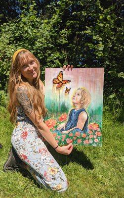 Artist Lily Rose showcasing her painting "Childhood Wonder" before it sold.