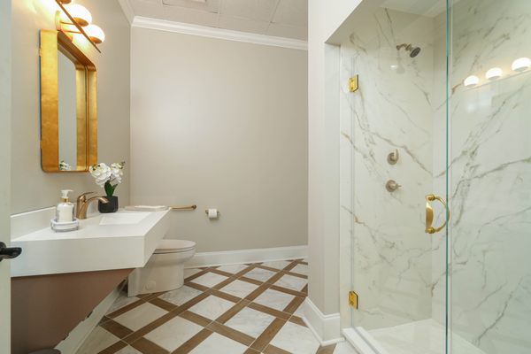 White quartz vanity countertop, porcelain shower walls and tile floor