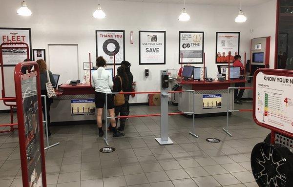 Spotless waiting room with service desk and cashiers. Both the employees and the customers were all wearing masks.