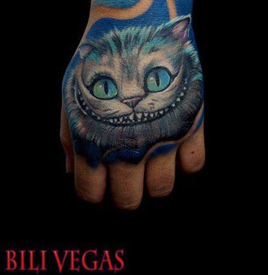 Cheshire cat hand tattoo by traveling pro artist Bili Vegas