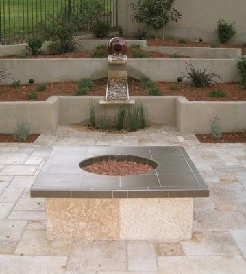 Modern waterfall, firepit, and travertine tile patio