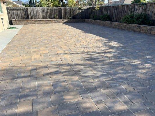 backyard patio paving installation with retaining wall flower box bench seats