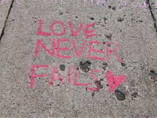 "Love never fails," written on NCF's sidewalk in chalk on Sunday, April 24, 2022.