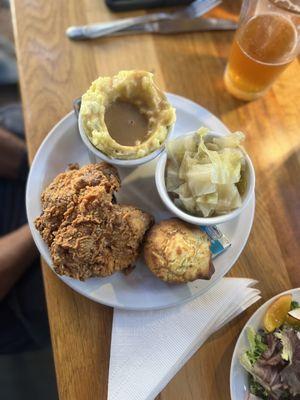 Fried chicken breast with potatoes and gravy, steamed cabbage and cornbread.