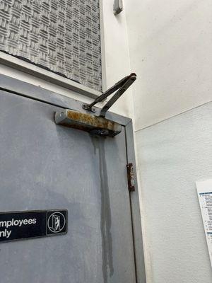 A outdated manual door closer that needed removed and replaced.