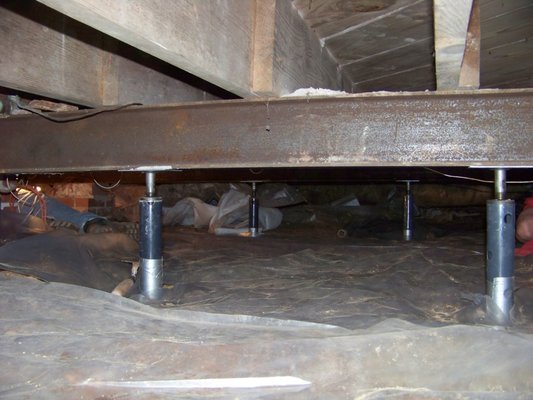 Steel girder, floor system stabilized in crawl space; concrete footers with steel jack post and steel girders