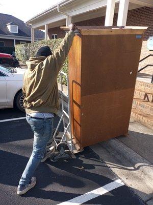 Carefully. Moving a dresser.