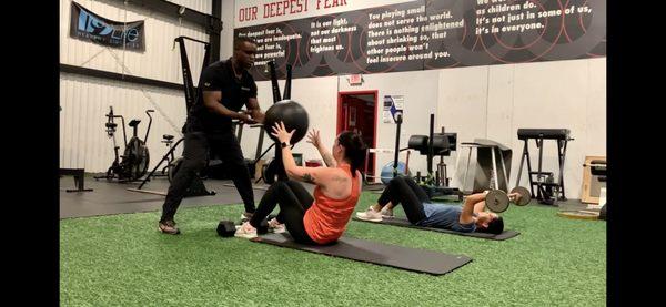 Group session working the core and triceps with heavy med ball and barbell.