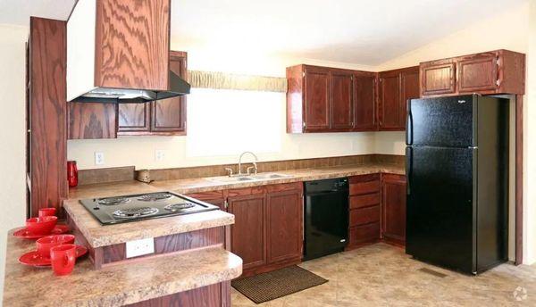 a kitchen with a black refrigerator freezer and a stove top oven