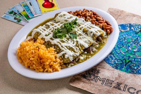 Chicken enchiladas cover is salsa verde - topped with chopped cilantro, onions, sour cream and powdered cotija cheese, accompanied with rice