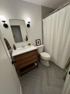 After of the renovated guest bathroom. Love my herringbone floors, thank you Oscar!