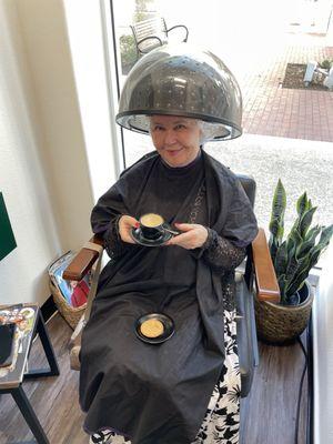 una bella donna che prende un caffè e mangia un biscotto.