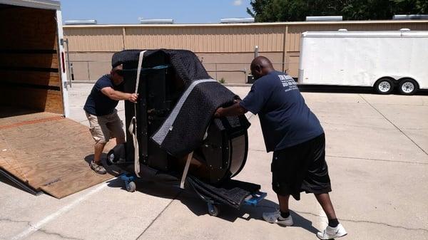 Loading a high value piano on a custom piano dolly for delivery.