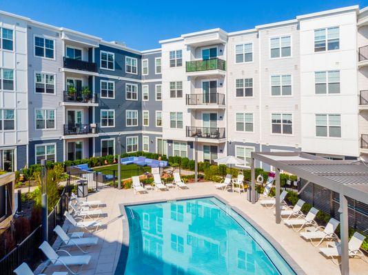 Pool with lounge chairs and view of apartments