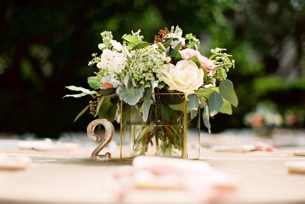 A centerpiece shot. I bought these square candle holders & table numbers at BHLDN. DB used round vases inside the candle holder -my fav arrg