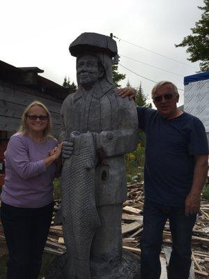 Sherry and Bob with wood carving of Dad, Willard "Sully" Kauppi.