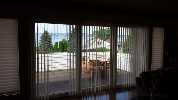 Graber Super view fabric vertical blinds on a patio door  with coordinating pleated shades on side windows. 