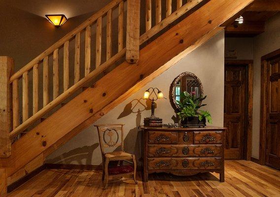 Vignette under the stairs in a log cabin using french antiques