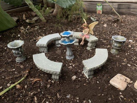 Adorable set of benches, urns, and a fountain, creating a wonderful formal-garden space.