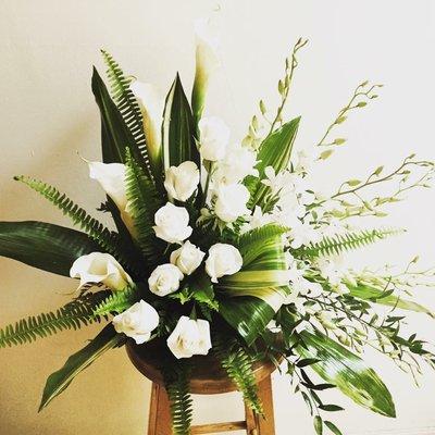 Arrangement with white tulips and green accents.