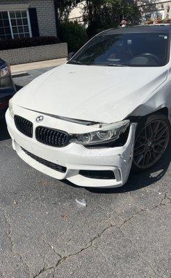 White BMW with front end damage