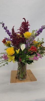 Tall and showy vase with fall and summery flowers.