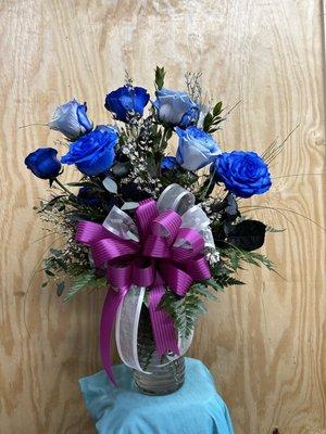 One Dozen Blue Roses in a vase with greenery and filler