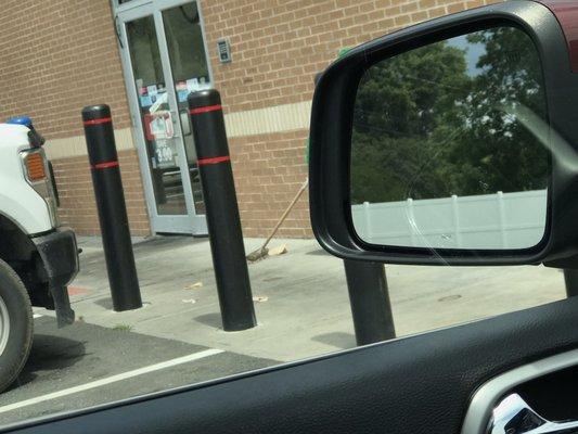 Trash outside with lone broom.