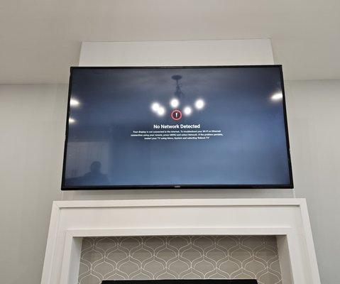 75" TV mounted above the fireplace.