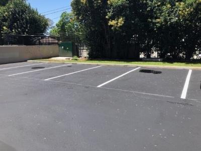 Puddles of water on top of the newly paved parking lot