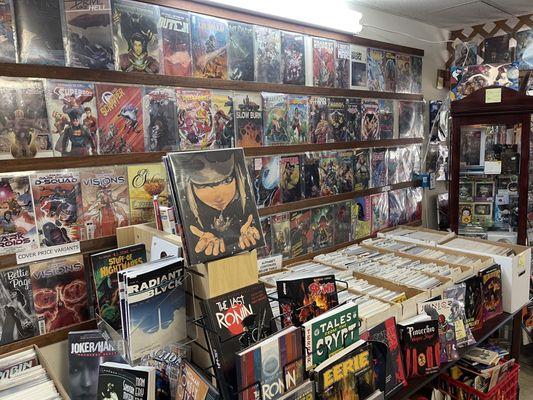 The wall of new comics, which come out on Wednesdays, above back issue boxes and graphic novels.